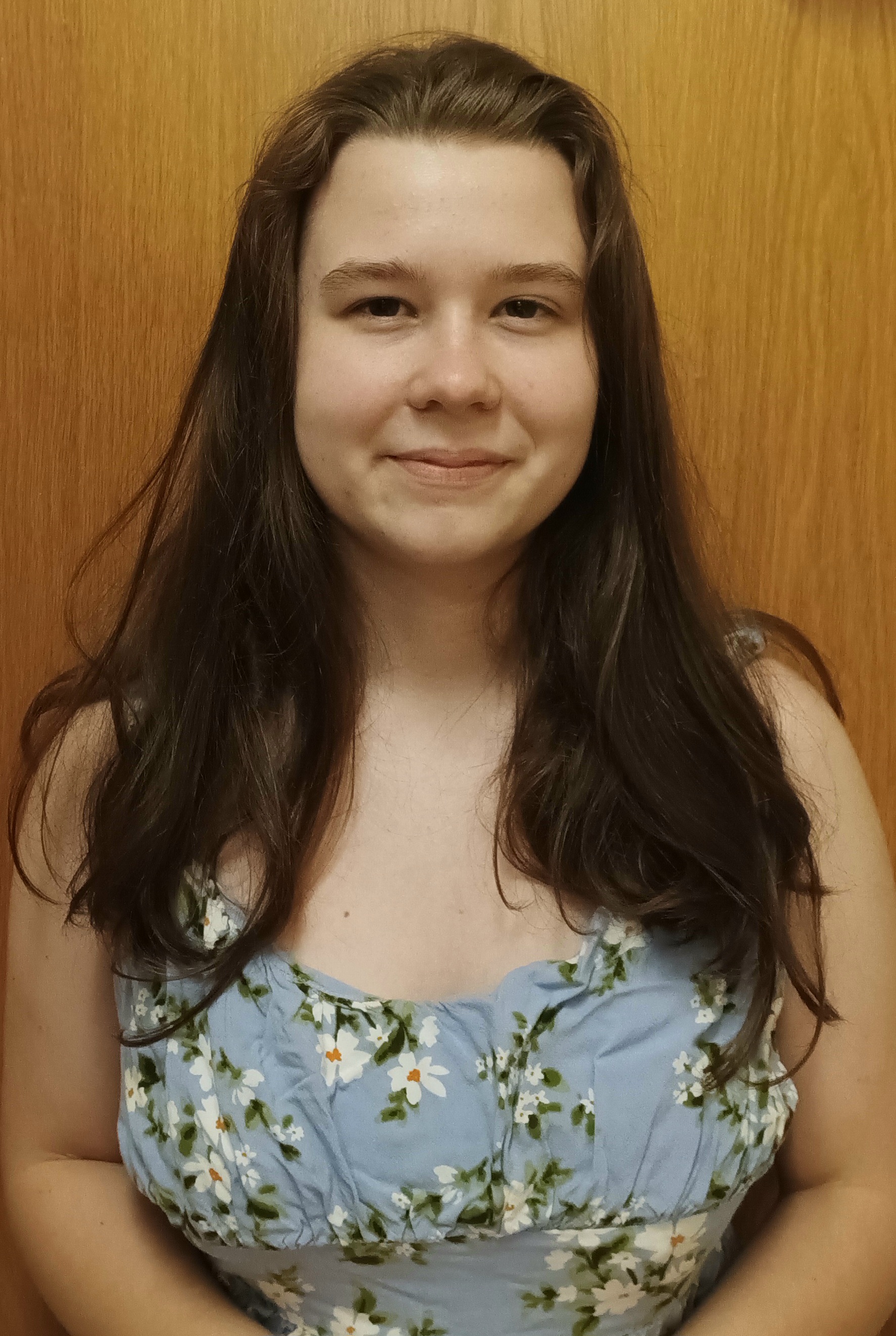 woman with a blue floral dress and shoulder length brown hair